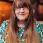 Angie, Finance and Resources Manager in Wood Hall smiling at the camera